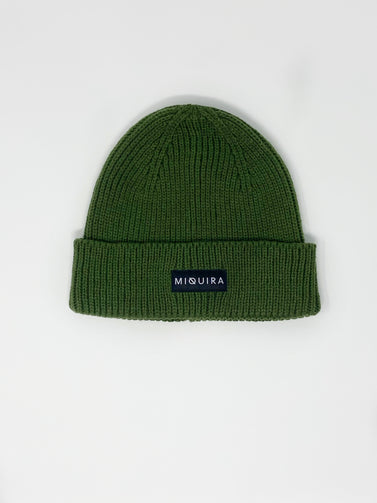 Forest green acrylic knitted beanie with black Miquira label stitched on the outside.